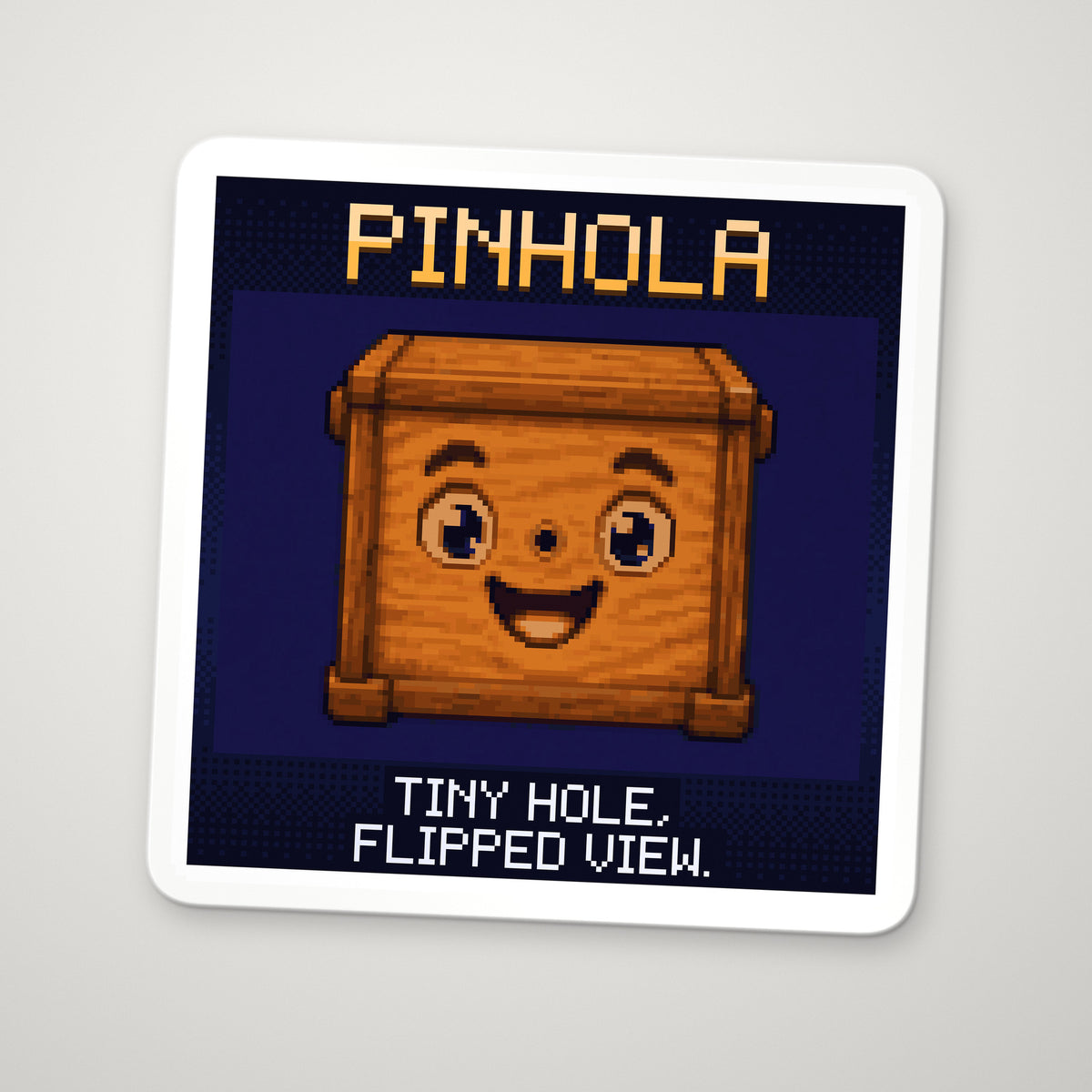 Pixel-art sticker of Pinhola, personifying The Pinhole Camera, with the caption “Tiny Hole, Flipped View.”