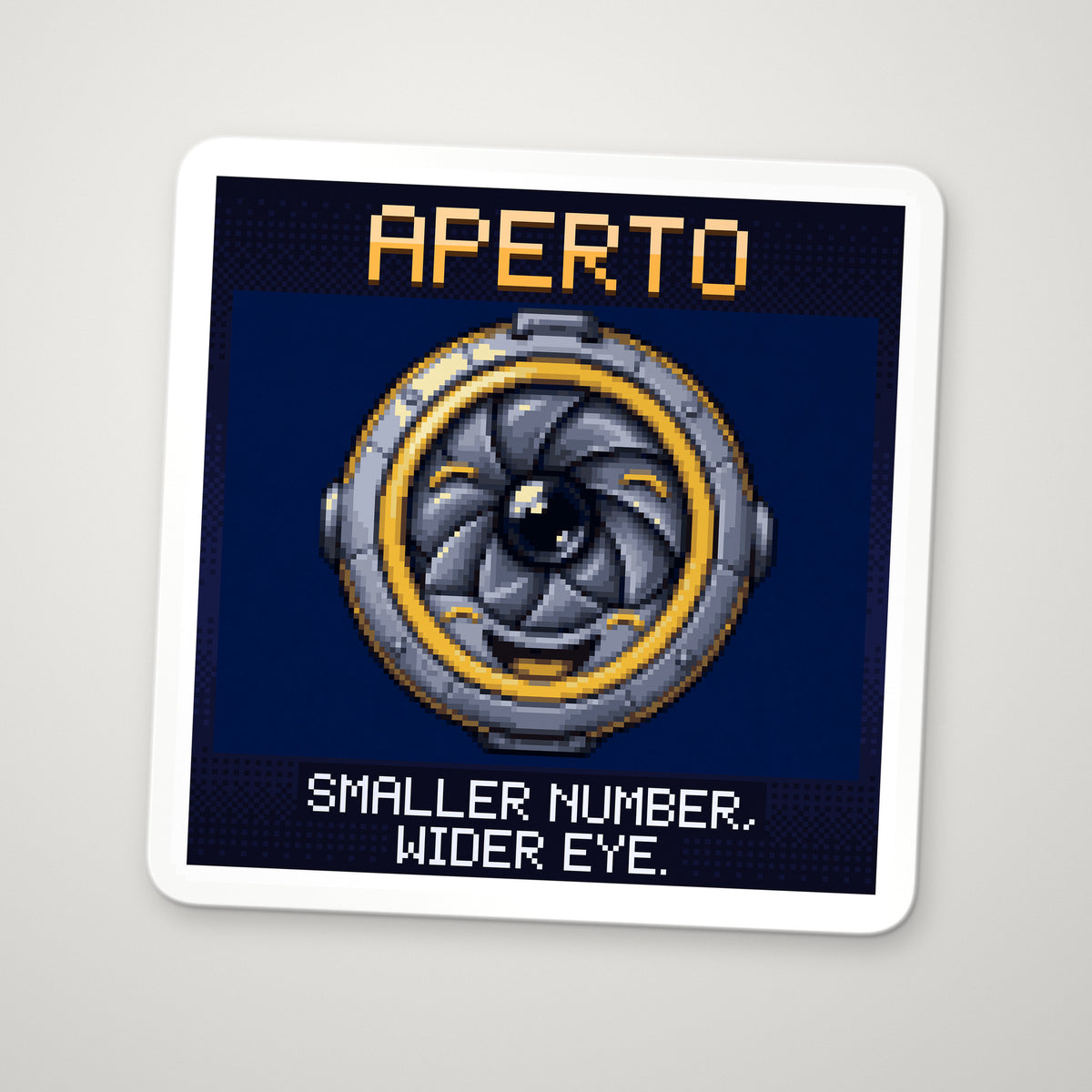 Pixel-art sticker of Aperto, personifying f-number of a Lens, with the caption “Smaller Number, Wider Eye.”
