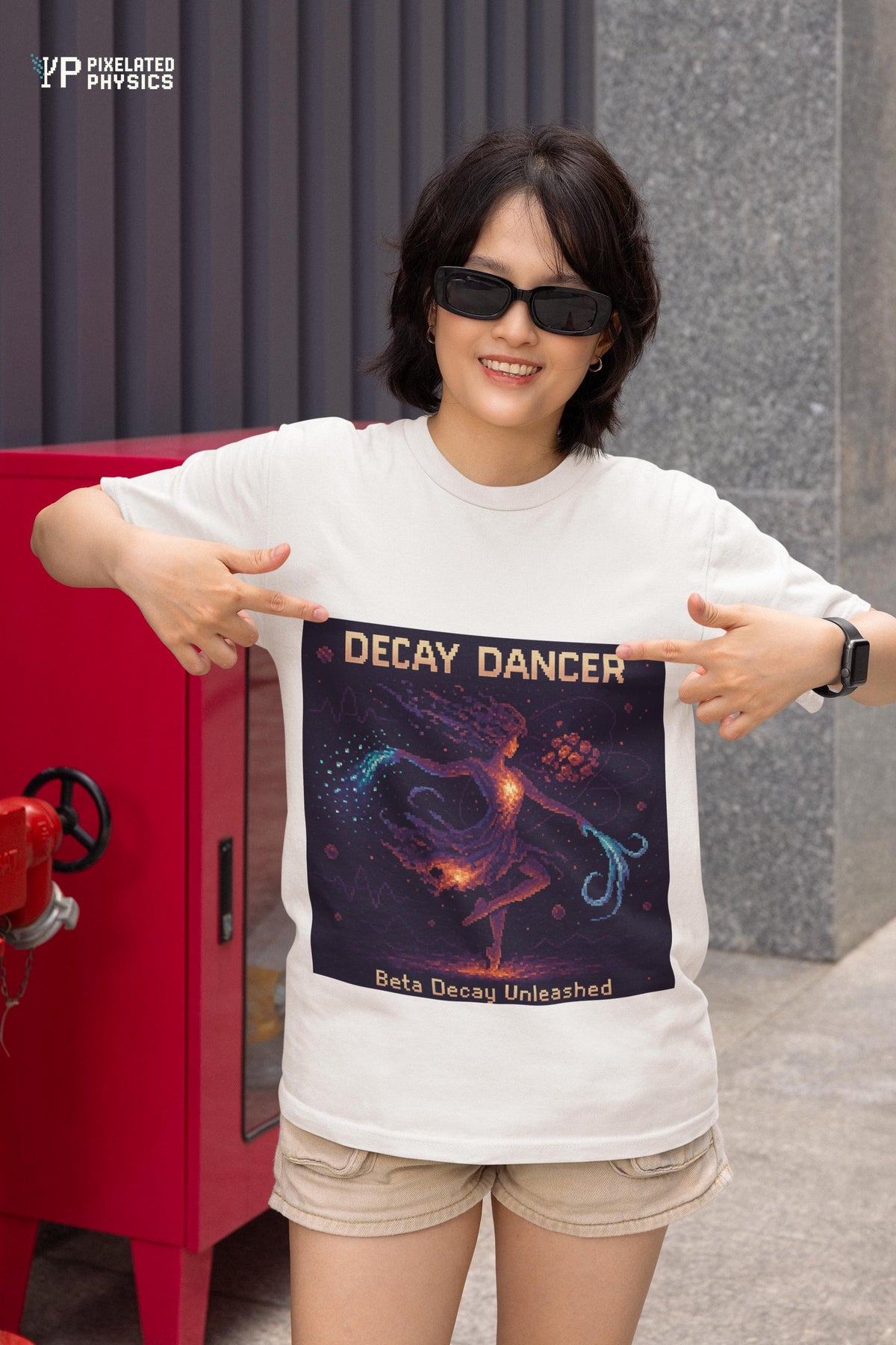 White Decay Dancer physics T-shirt, pixel-art beta decay design, worn by a woman